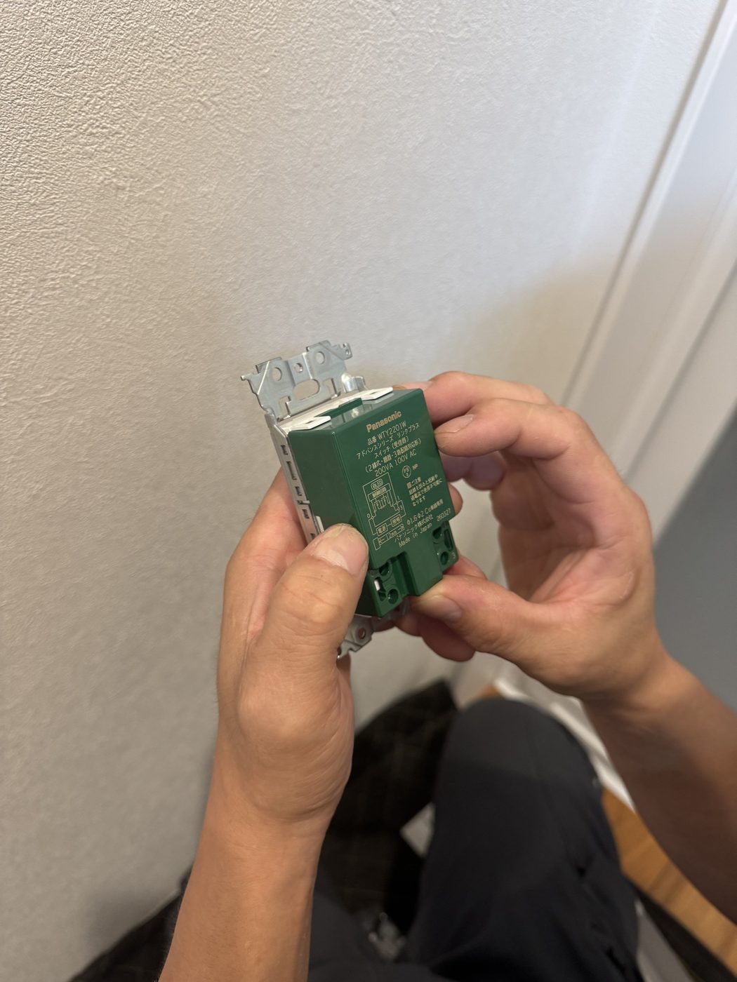 Panasonic リンクプラスのスイッチ（受信器・2線式）を手に持ったところ